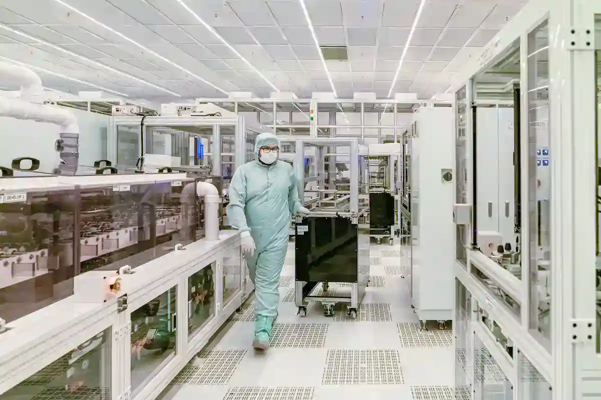 半導體晶圓廠無塵室內的自動化製造設備與工程人員，呈現半導體設備精密零件的潔淨製程環境