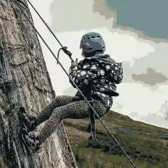 攀岩者使用安全吊帶與攀登繩索進行戶外岩壁攀登，呈現登山用品與攀岩裝備應用